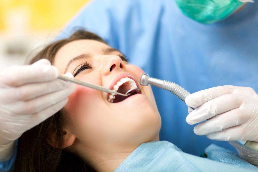 A dentist examining a smiling woman.