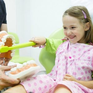 A young girl in a dentists chair.